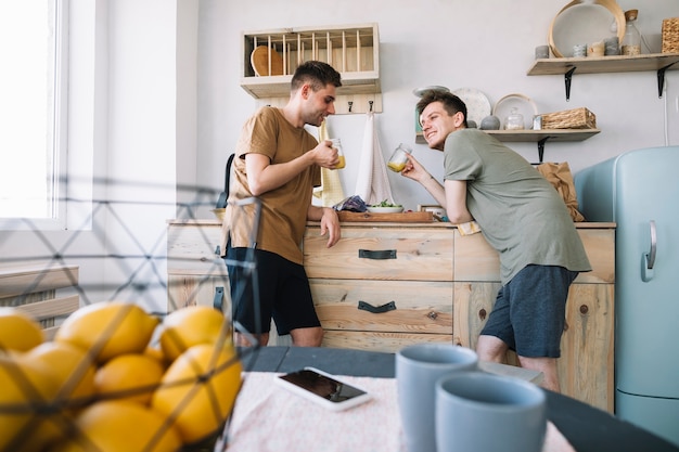 Free Photo happy friends enjoying drinking juice in kitchen