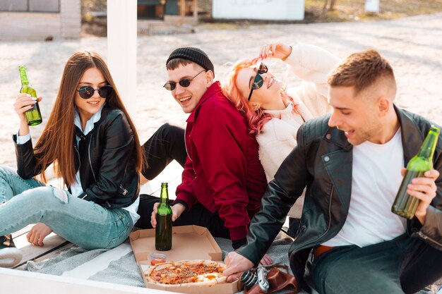 Happy friends having party sitting on ground