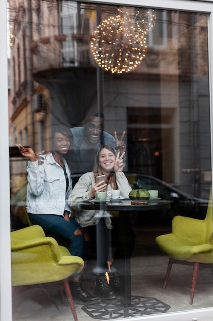 Happy friends posing through window