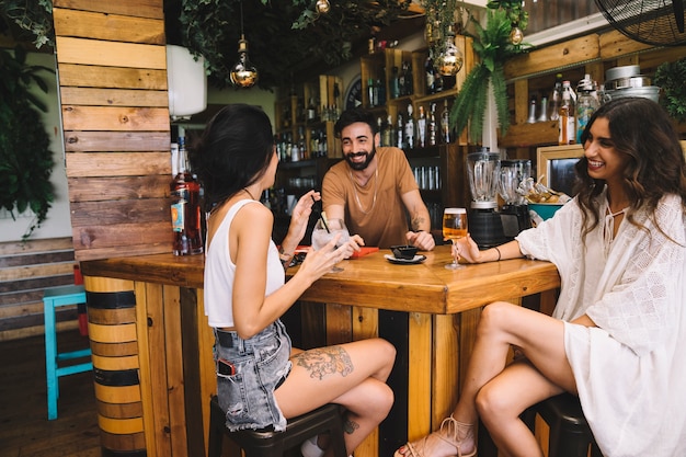 Happy friends talking at table