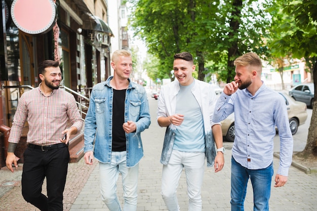 Happy friends walking together on pavement