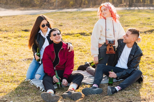 Happy friends with beers having fun together on open air party