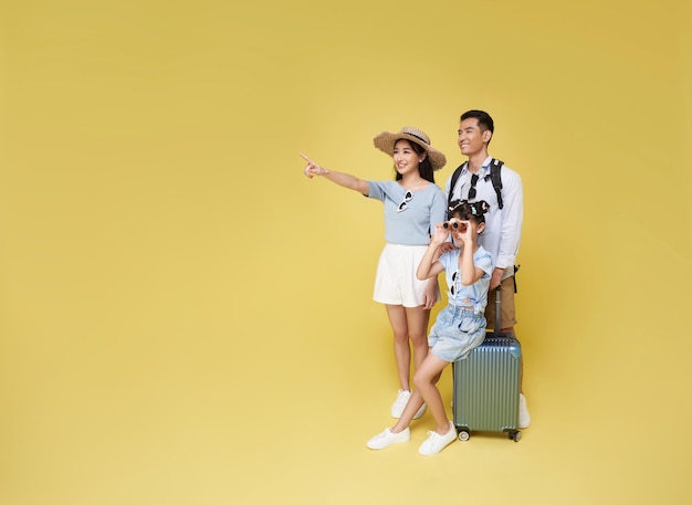 Happy fun asian family vacation portrait Father mother and daughters pointing finger copy space