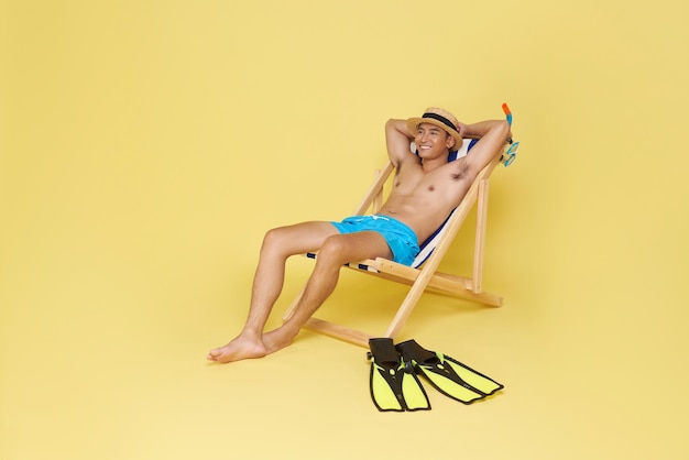 Free photo happy fun cool tourist asian man resting and relax on deckchair