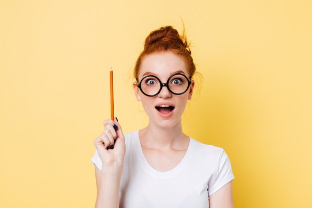 Happy ginger woman in eyeglasses having idea