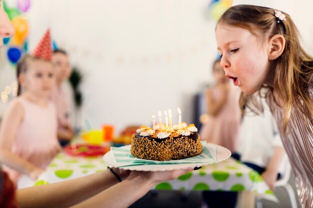 Happy girl blowing candles on cake