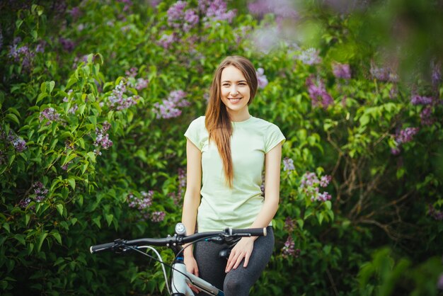 Happy girl cyclist standing with a mountain bike and. Adventure travel.