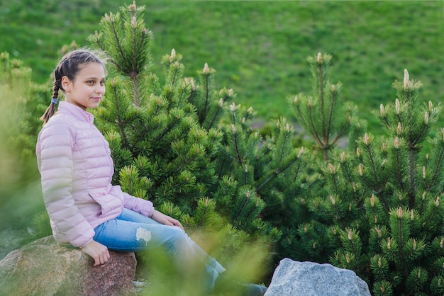 Free Photo happy girl sitting on a rock