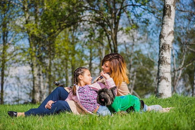 Happy girl sitting with her mother in the park