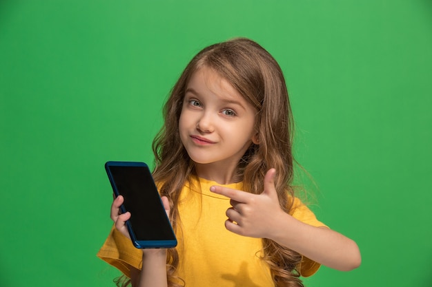 Happy girl standing and smiling with mobile phone