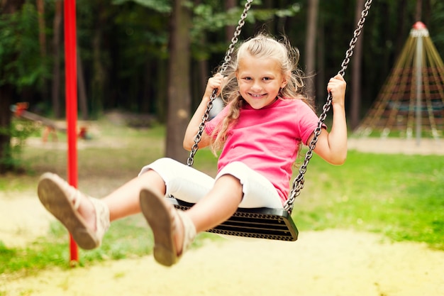 Free photo happy girl swinging on playground