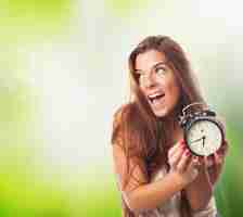 Free photo happy girl with alarm clock in hands