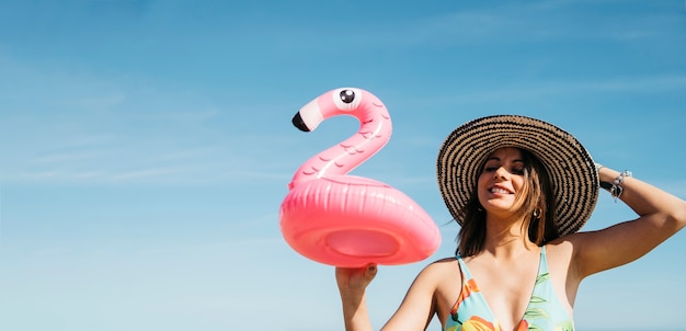 Free Photo happy girl with inflatable flamingo