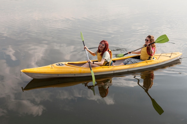 Happy girls rowing in kayak