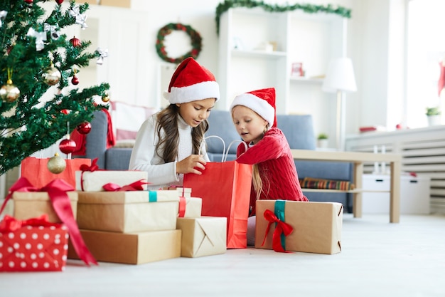 Happy girls unwrapping Christmas presents