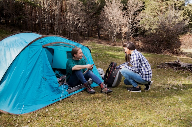 Happy girls with tent in the field