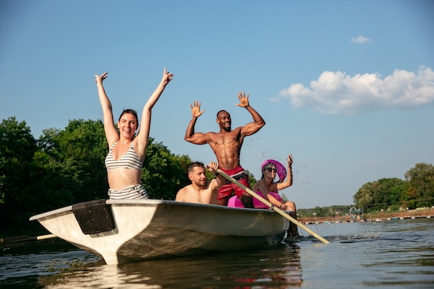 Free photo happy group of friends having fun while laughting and swimming in river