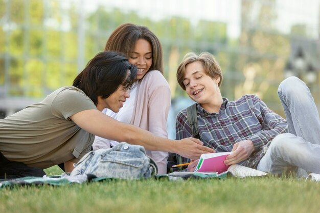 Happy group of multiethnic students studying outdoors