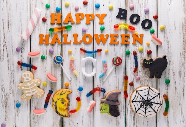 Free photo happy halloween caption with candies and cookies