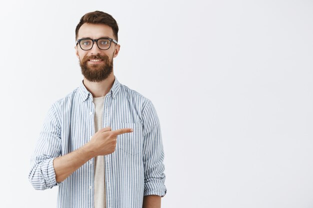 Happy handsome bearded man posing against the white wall