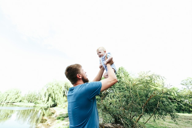 Happy handsome dad, father holding baby boy in blue clothes