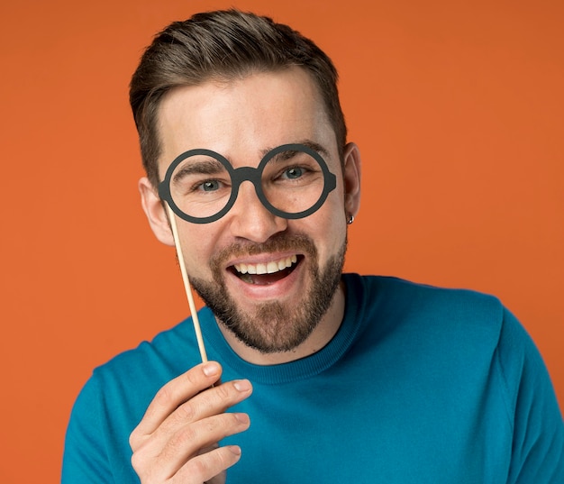 Free photo happy handsome man posing with fake glasses