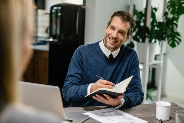 Free Photo happy insurance agent talking to a client and taking notes during the meeting