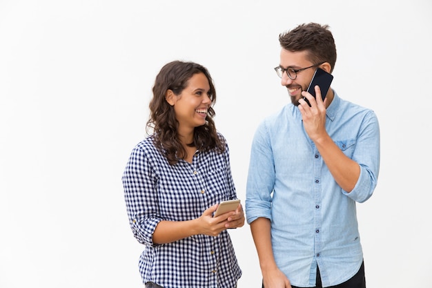 Happy joyful couple using mobile phones