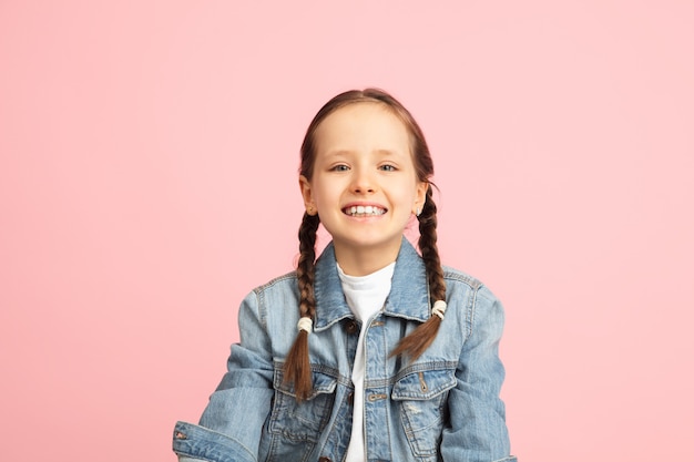 Free photo happy kid, girl isolated on  wall. looks happy, cheerful. copyspace childhood, education, emotions, business, facial expression concept. jumping high, running celebrating