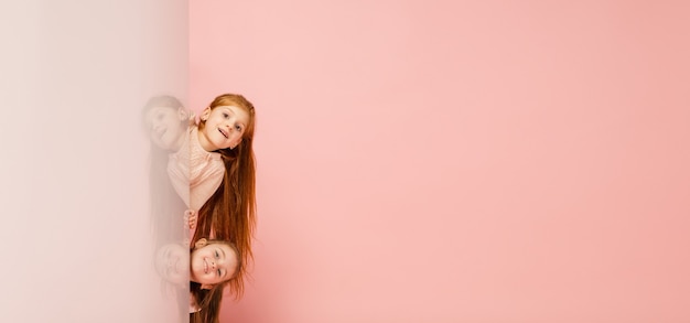 Free photo happy kids, girls isolated on coral pink