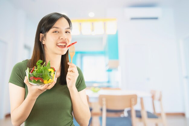 Happy lady holding kitchen stuff over copy space background