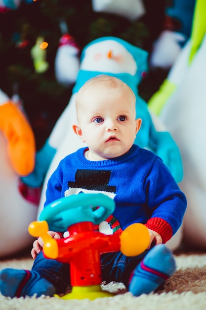 happy little boy near  toy snowman in studio