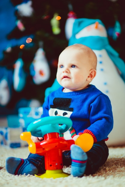 happy little boy near  toy snowman in studio