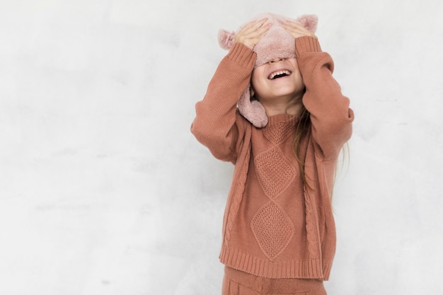 Happy little girl covering her face