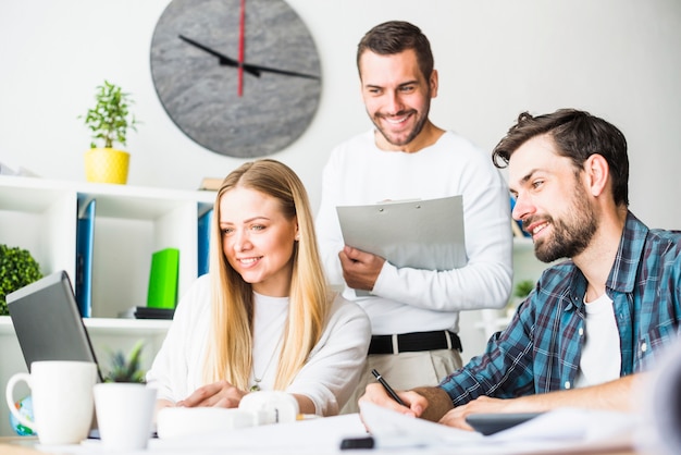 Free Photo happy male and female businesspeople working on laptop