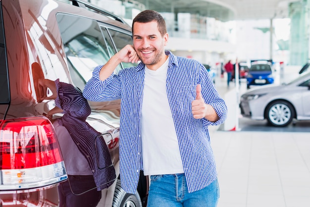 Happy man in car dealership