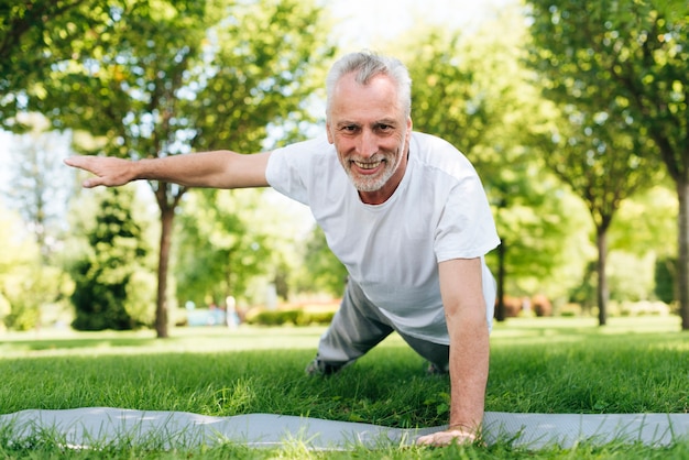 Happy man doing push-ups in nature