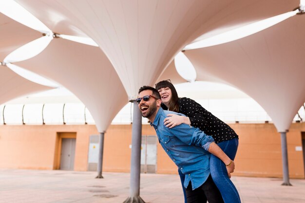 Happy man giving piggyback ride to her girlfriend