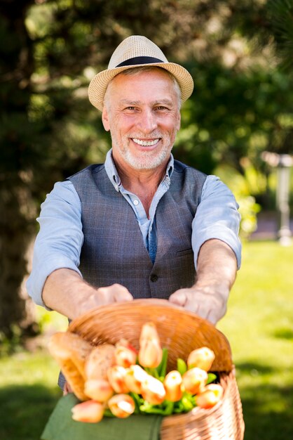 Happy man holding a basket with flowers