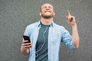 Free photo happy  man listening to music on earphones