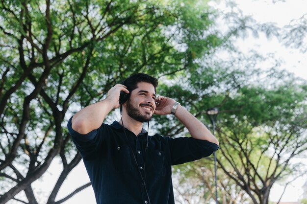 Happy man listening to music in park