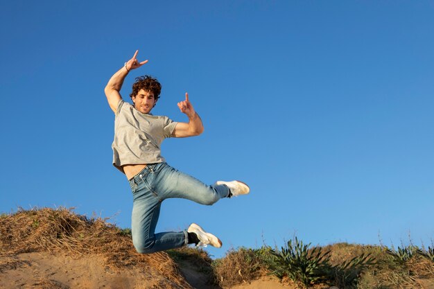 Happy man outdoors jumping up