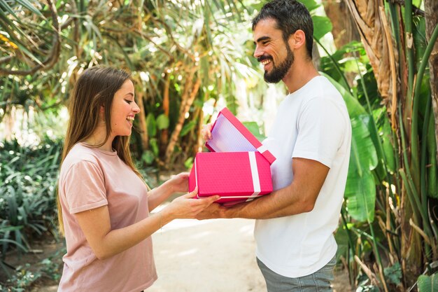 Happy man showing gift to his girlfriend in park