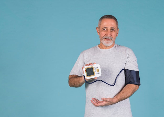 Free Photo happy man showing results of blood pressure on electric tonometer