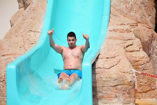 Happy man on the slide in the water park