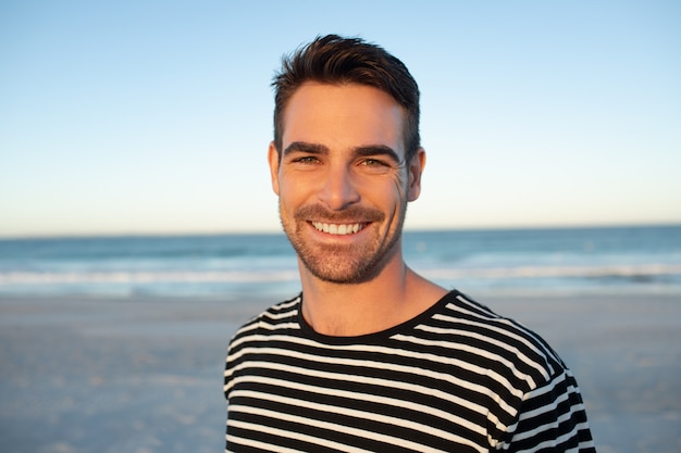 Happy man standing on the beach