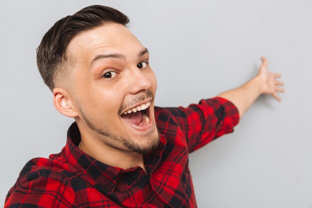 Happy  man standing sideways and posing in studio