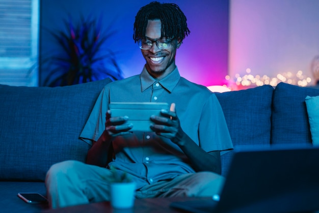 Happy man using his tablet at home on the couch