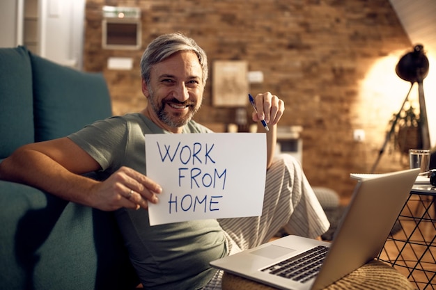 Free photo happy man wearing pajamas while working late at home