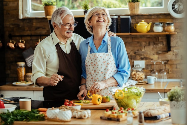 Happy mature couple preparing healthy food and having fun together in the kitchen